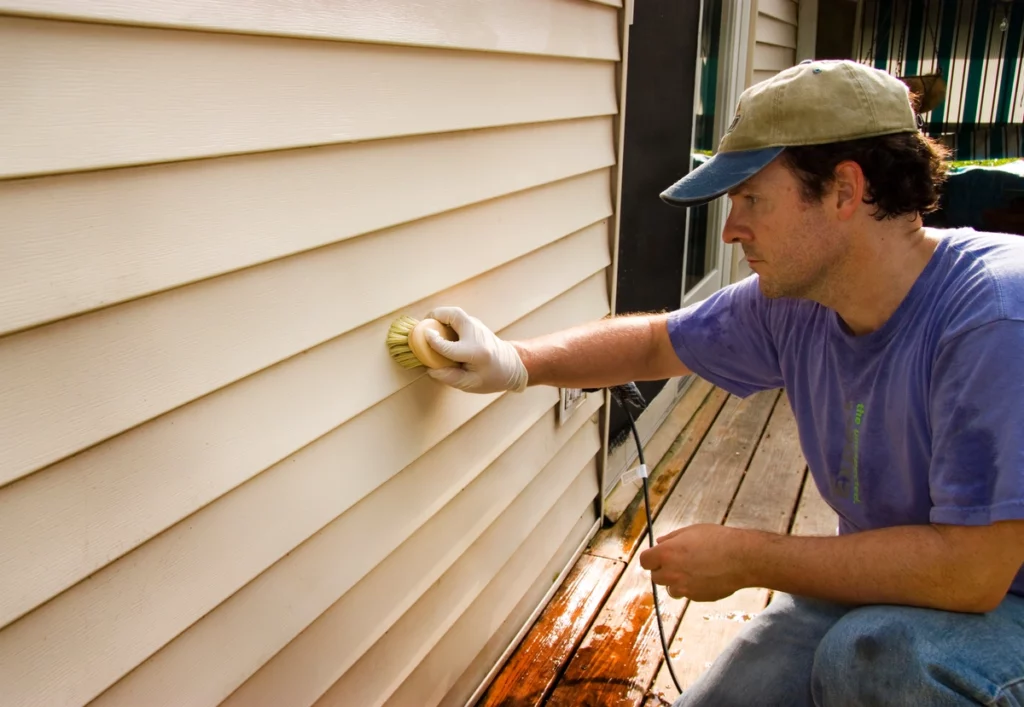 homeowner shows how to clean vinyl siding with scrub brush