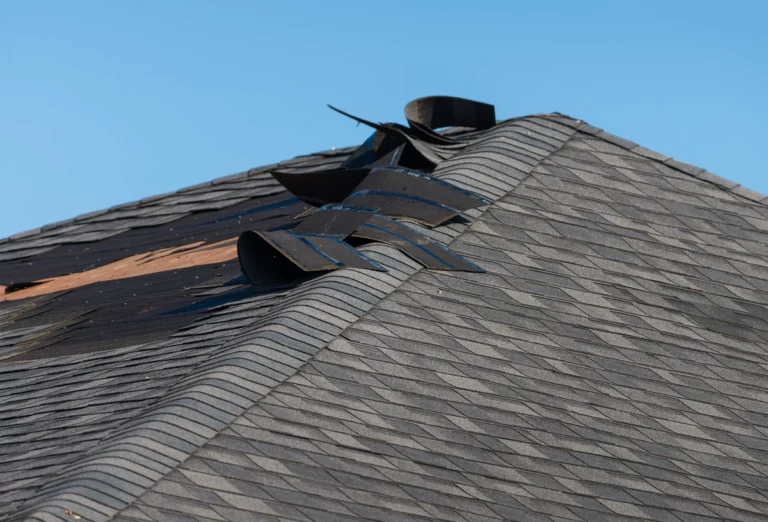 extreme wind damage to a roof with torn off shingles
