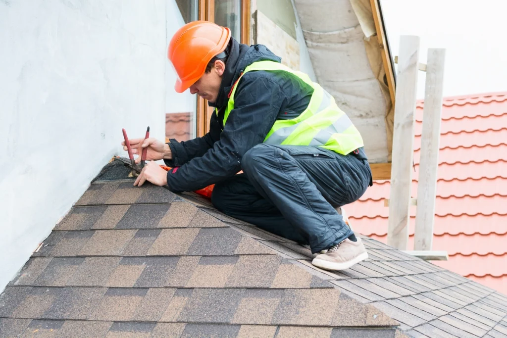 professional roofer repairing shingles of a roof