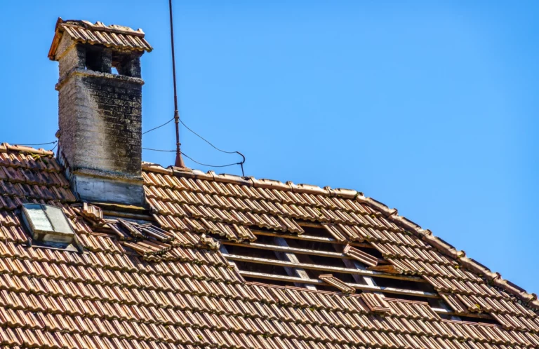 aged and damaged roof with a chimney