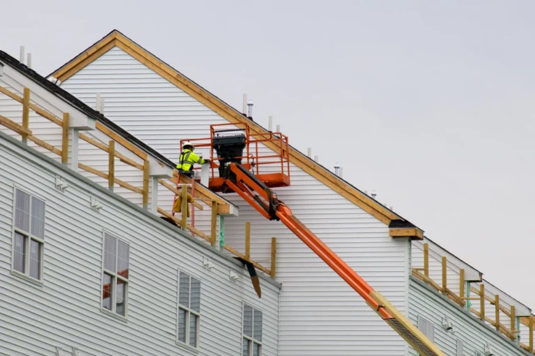 large house siding installation by worker