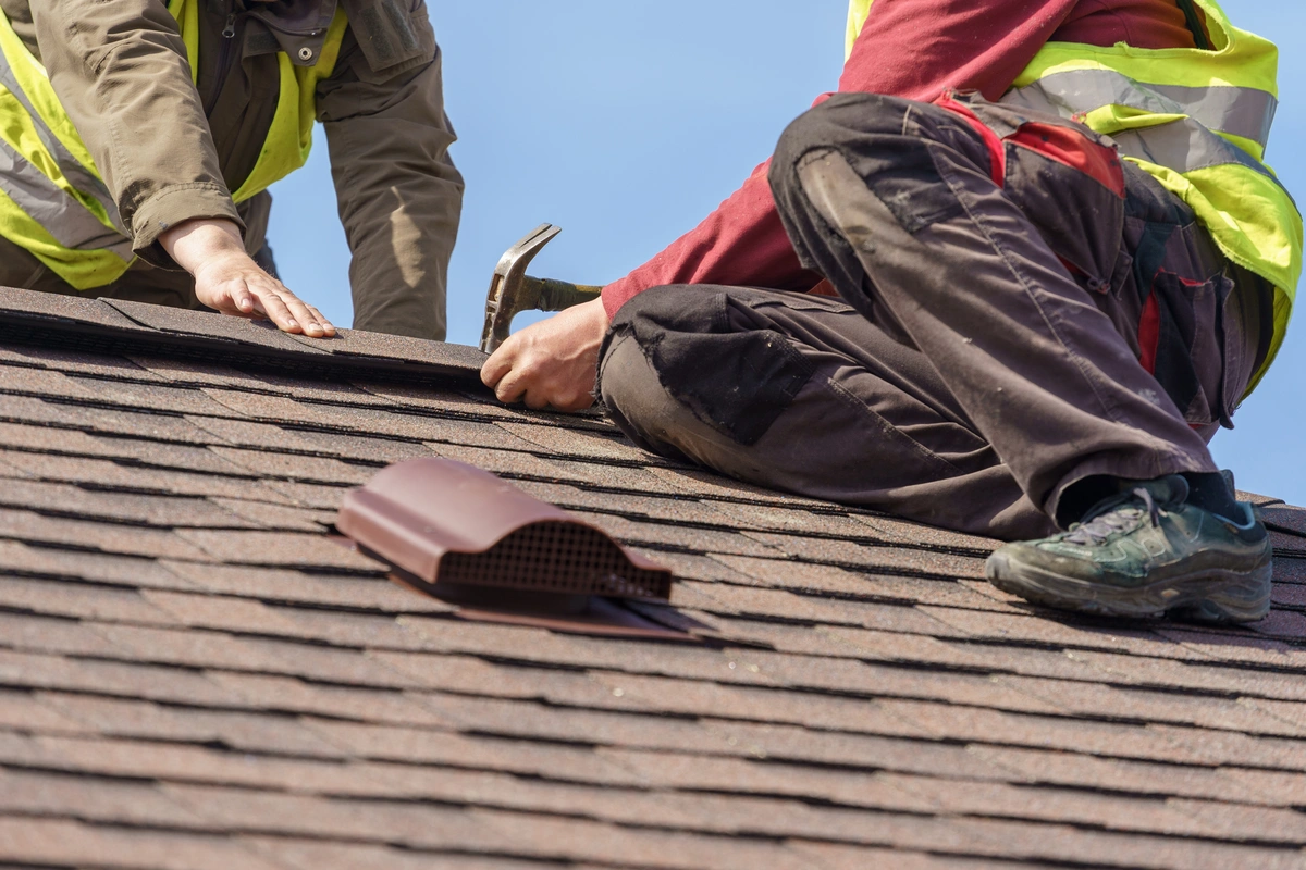 close up to workers repairing roofing shingles