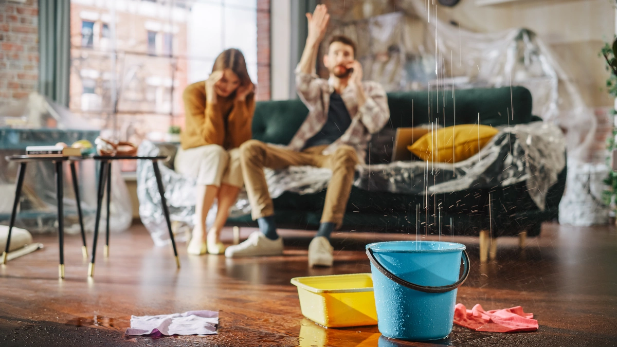 A couple on the couch are upset by their leaky ceiling