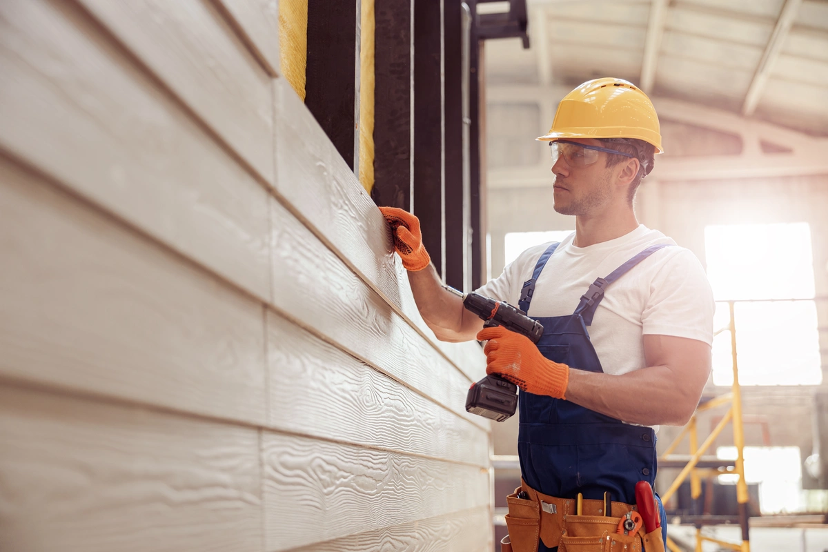 contractor examines vinyl siding