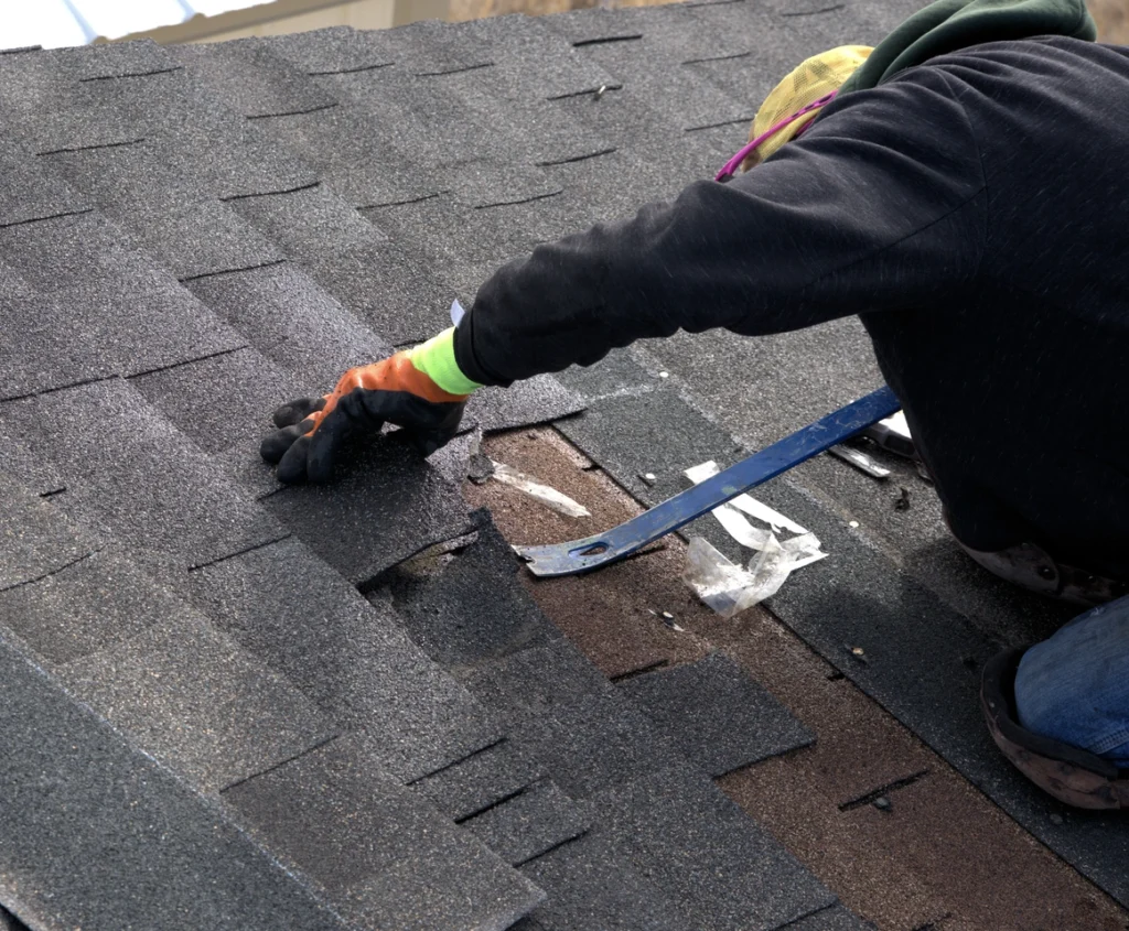 worker removing shingles-tear off roof