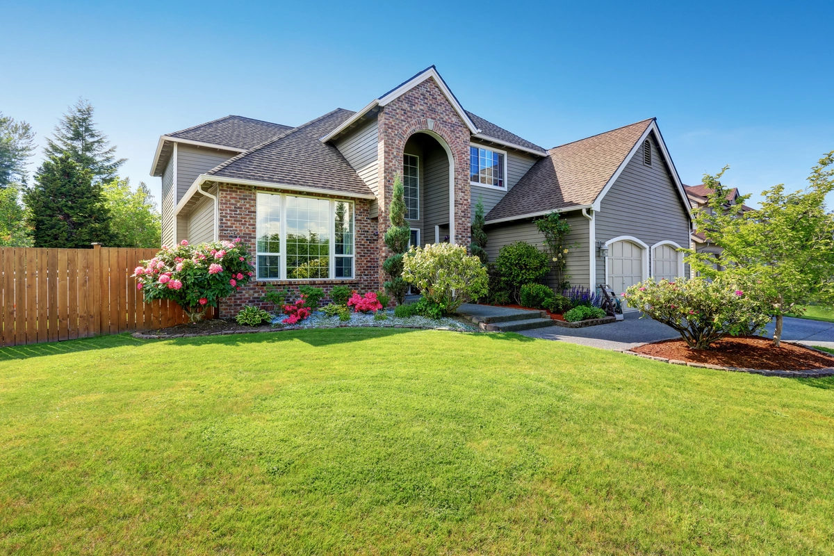 storm damage repaired home with a green lawn and landscaping