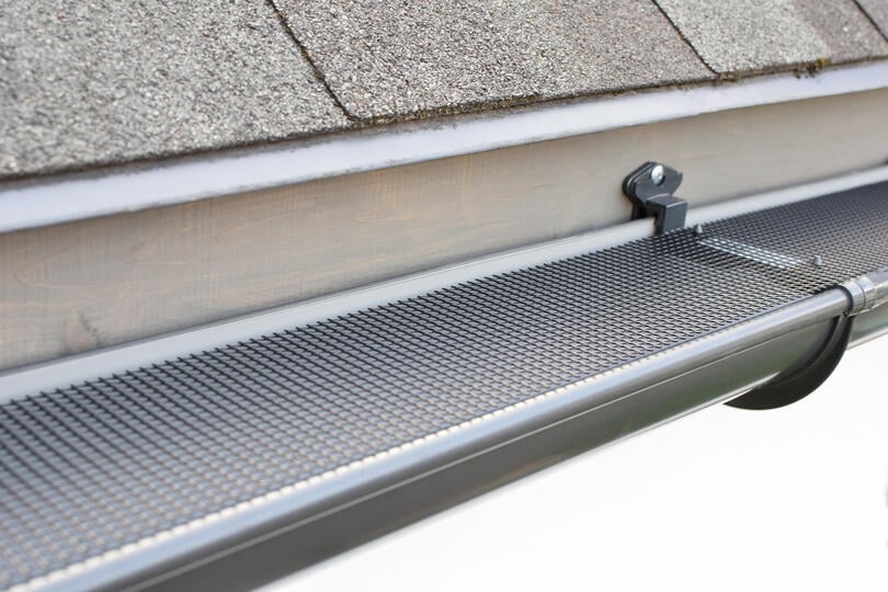 leaf filter gutters-mesh gutter guards shown on metallic gutters attached to a house