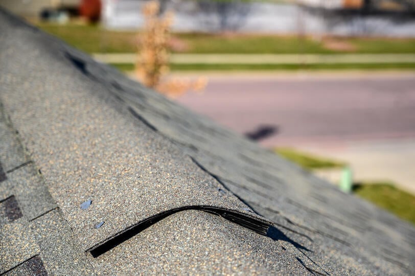 ridge cap shingles-view of house peak with ridge cap shingles with a neighborhood street in the background