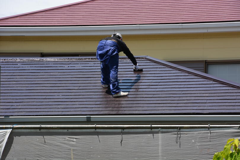 roof coating-roof tech rolling a coating on to a sloped roof