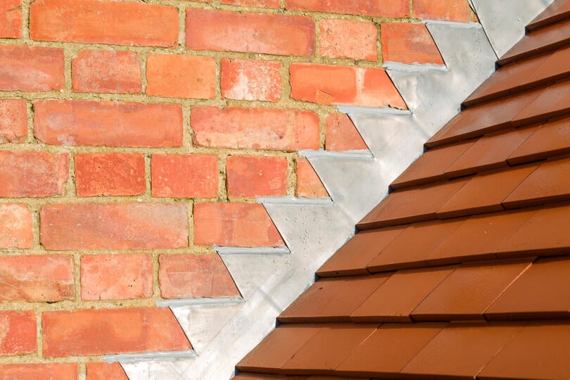 roof flashing repair-step flashing between brick wall and shingled roof