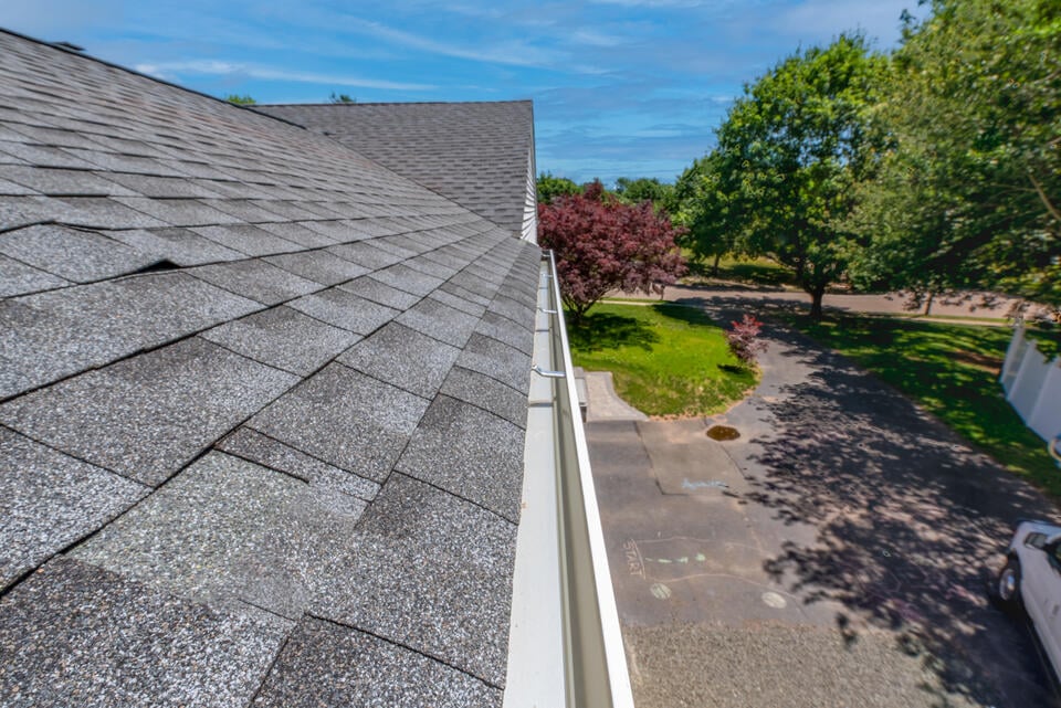 how much does gutter cleaning cost-house with gray shingles after getting gutters professionally cleaned