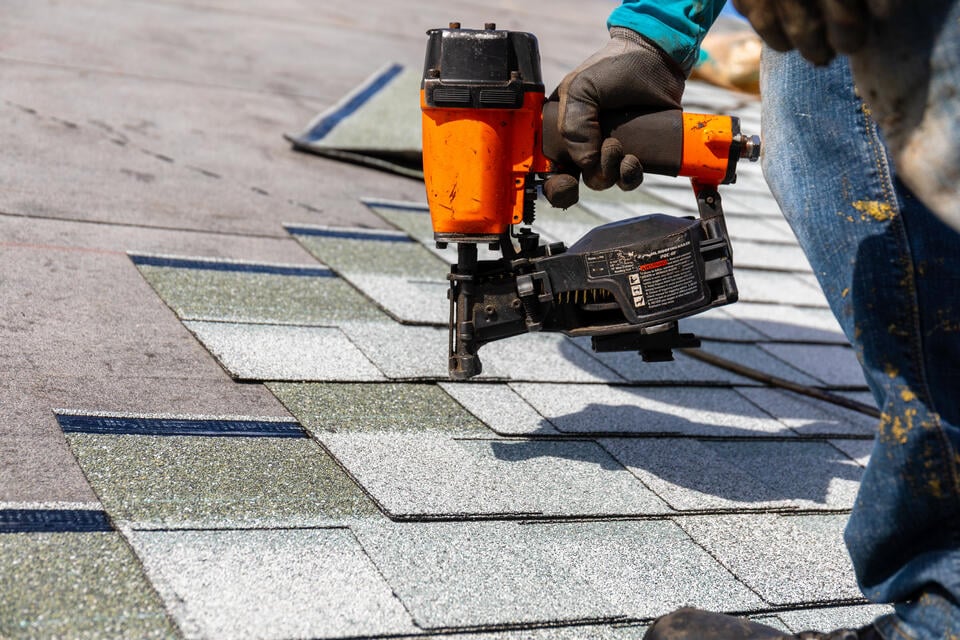 new roof installation-close up of someone installing new shingles on a house roof