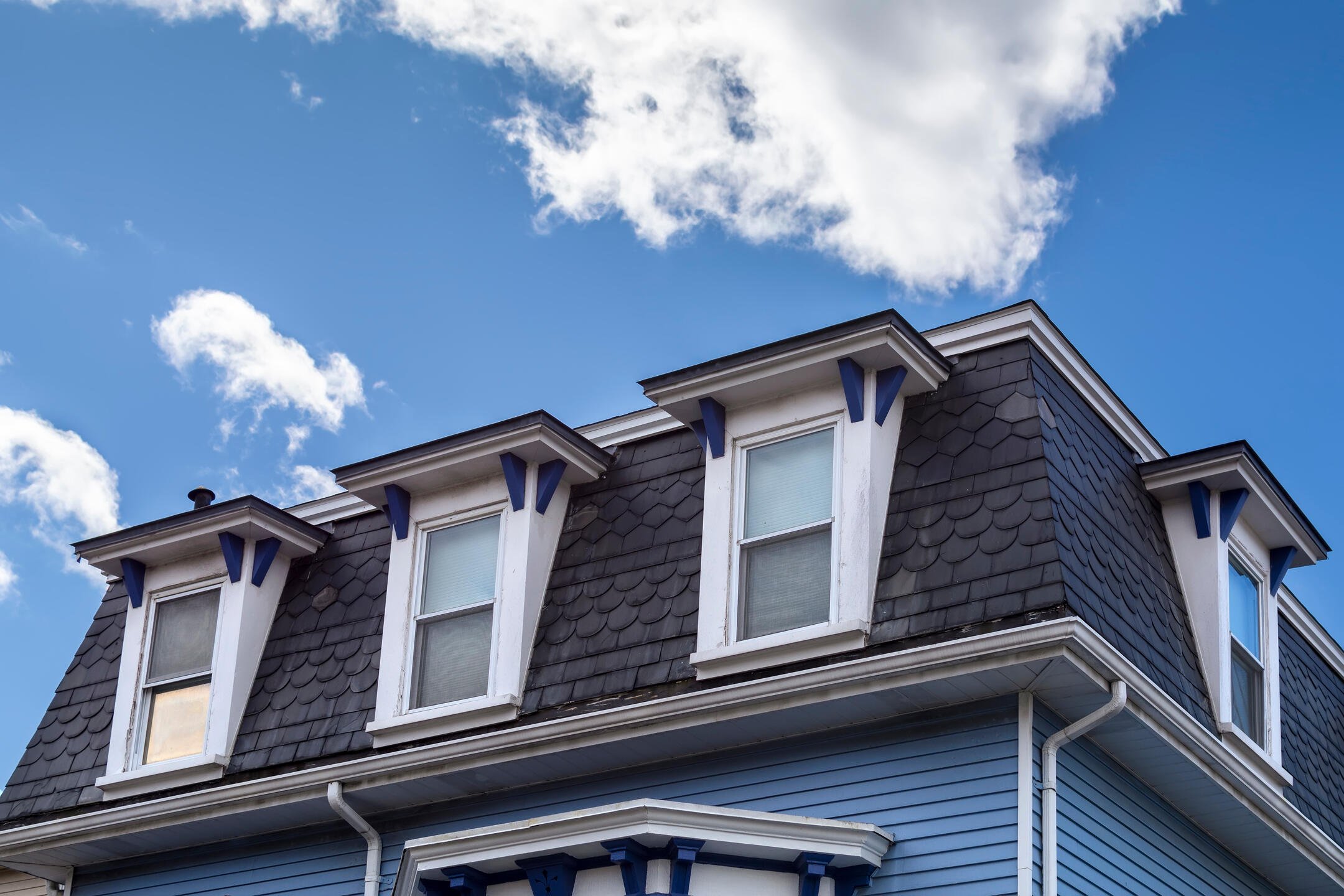 modern roof-blue sided house with a mansard roof