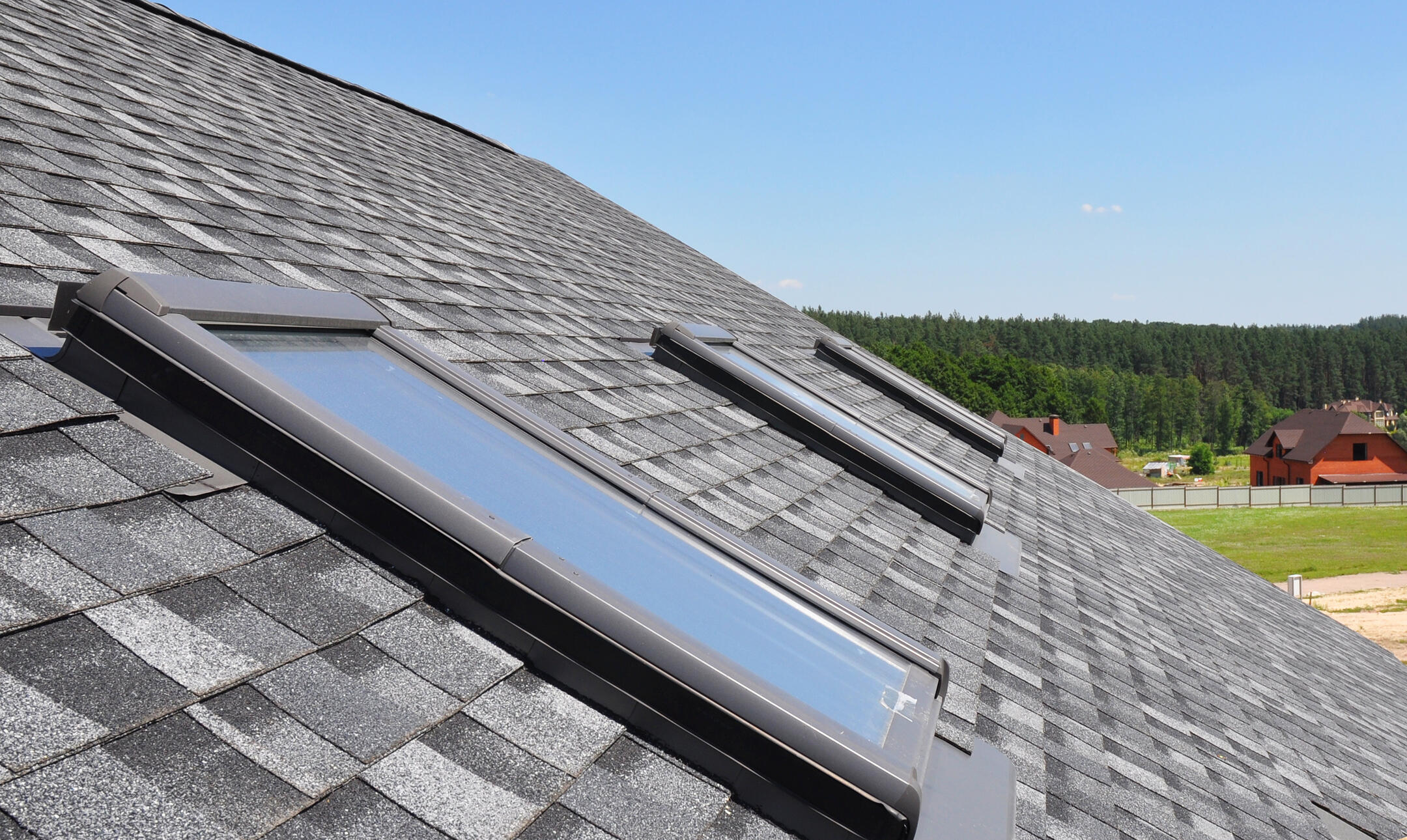 skylight flashing-close up of 3 skylights on a shingle roof