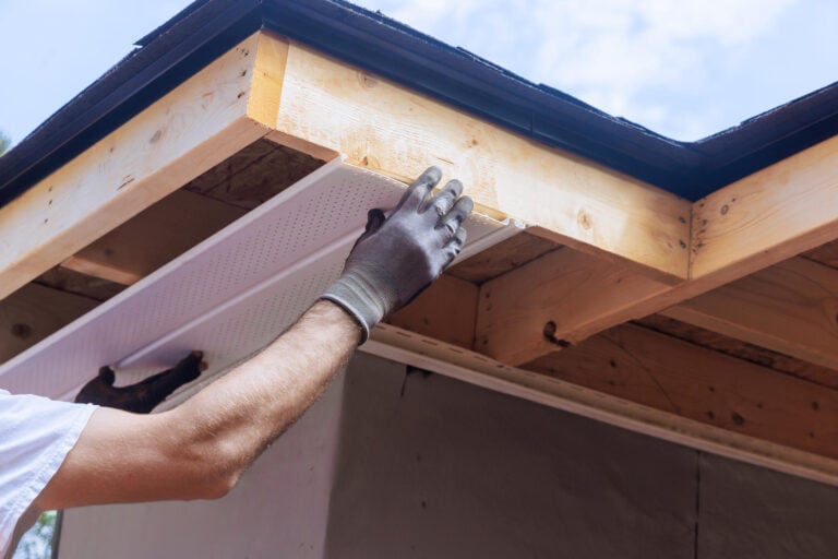 soffit repair-close up of a man installing new soffit materials on a home