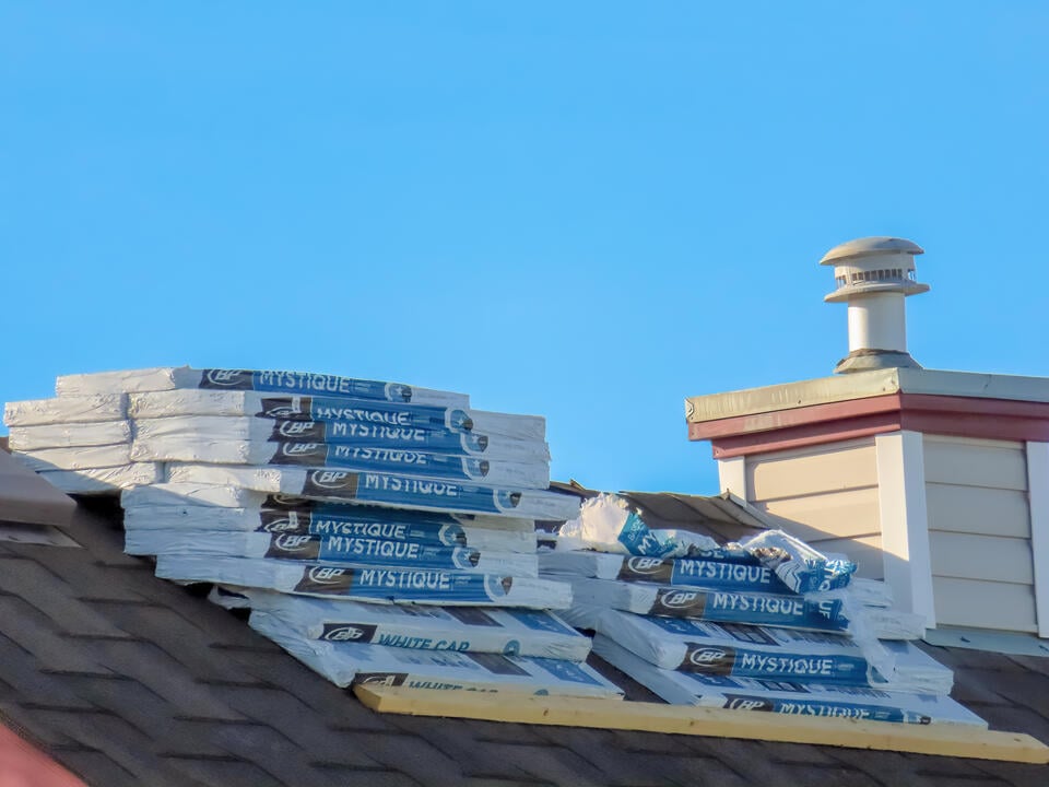 how many shingles in a bundle-close up of shingle bundles stacked on roof