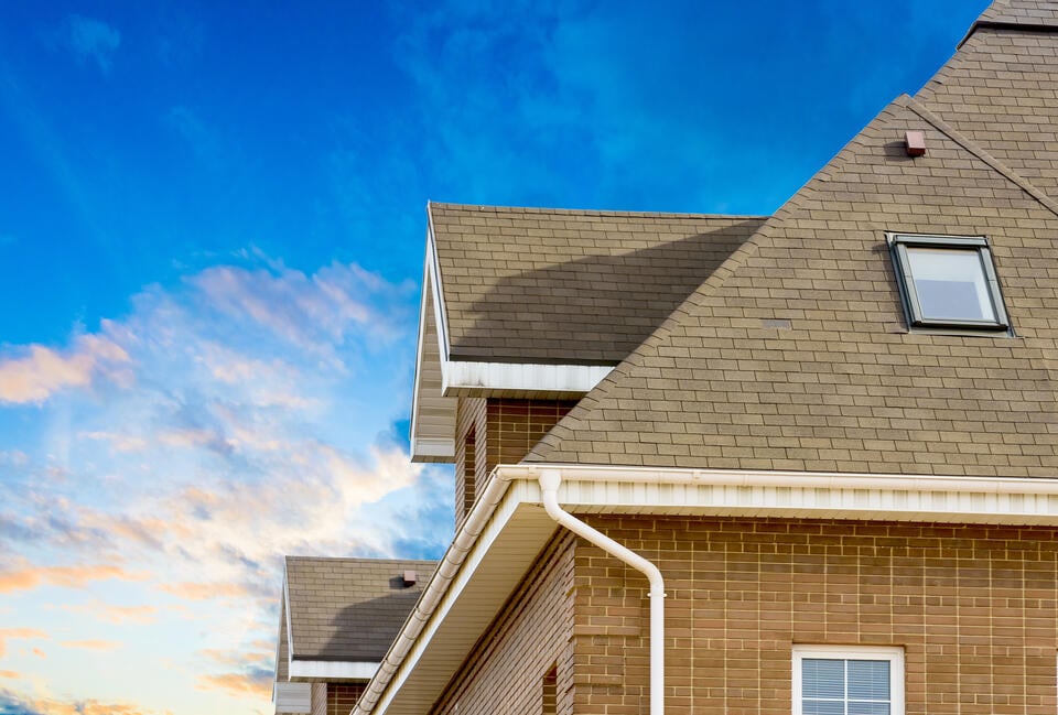 brick house with new shingle roofing