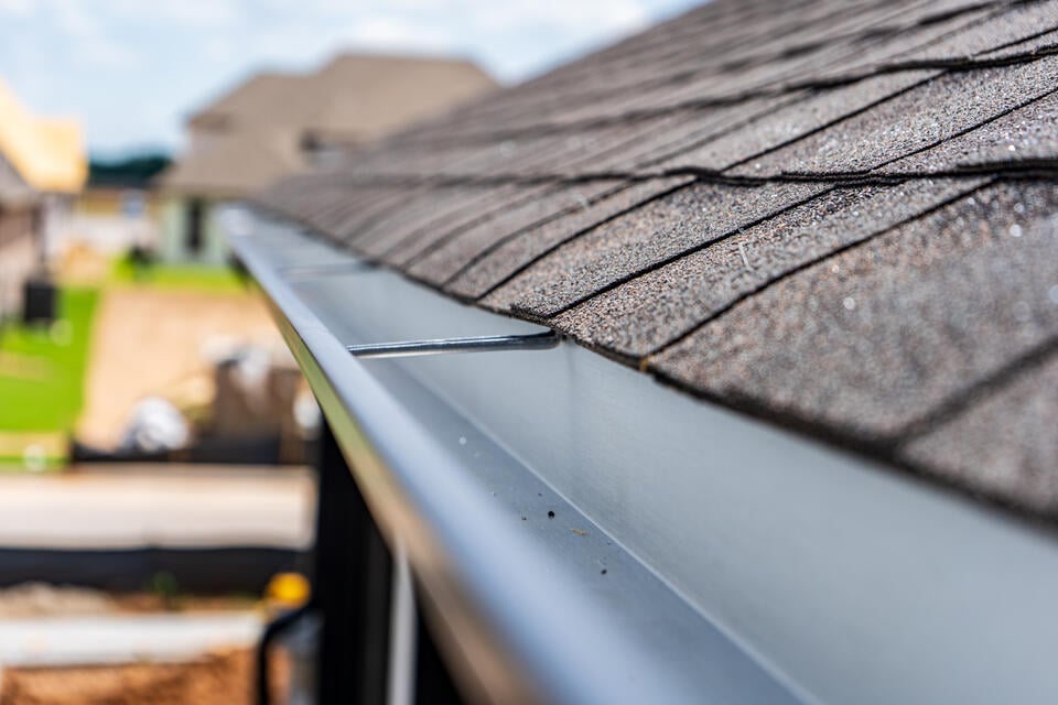 close up of metal gutter system on a shingle roof