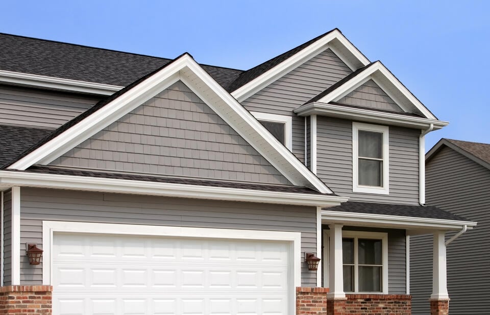 fiber cement siding vs vinyl-gray vinyl siding on a suburban house