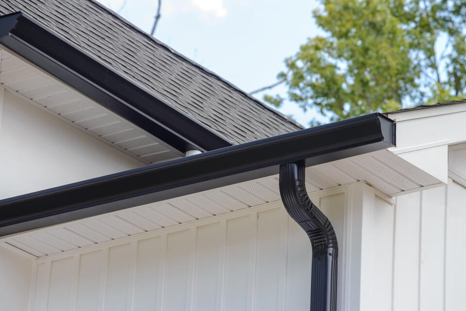 roof eaves-gutter system included in eaves on white sided house