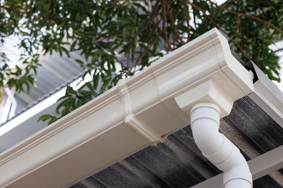 underside view of white gutter system on a house roof