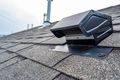 a home with a black roof vent