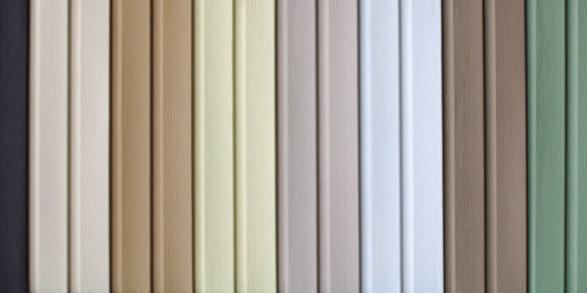 multicolored strips of vinyl siding samples for facing the walls of buildings as a background.