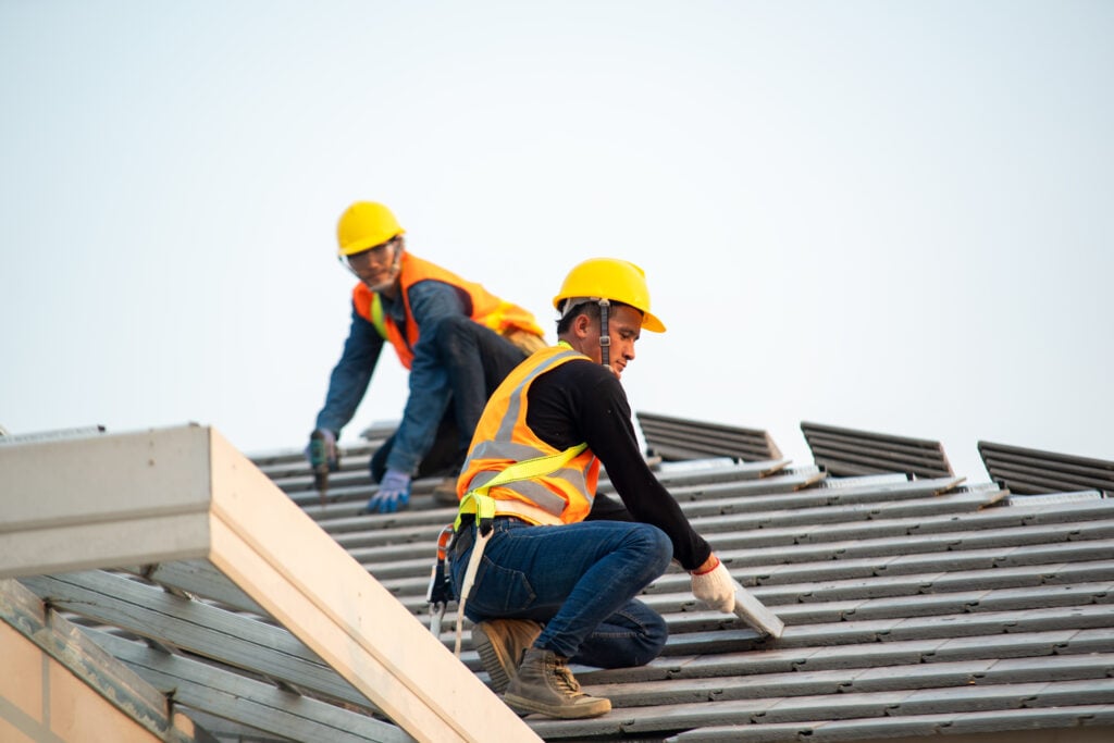 Roof repair,Construction worker using nail gun to install new roof on top roof,Residential building under construction concept questions to ask a roofer before hiring